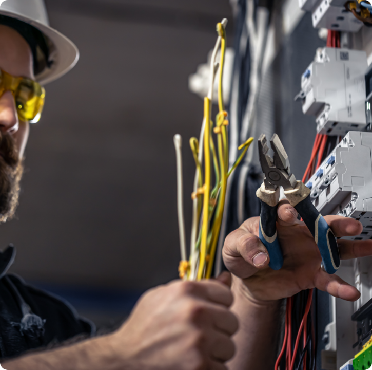 a_male_electrician_works_in_a_switchboard_with_an_2025_03_31_09_57_18_utc